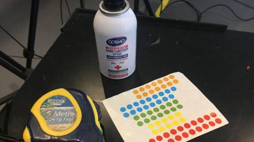 Table with  a measuring tape, some sticky dots  and a bottle of glue